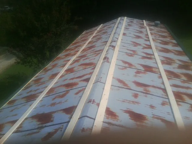 Rusted metal roof panels with new wood purlins before replacement — Storm Damage Roof Repair in Bigelow by Roofing Brothers